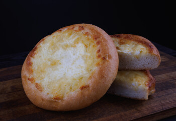 Khachapuri. Bun with cheese on a wooden background. Cheese pie.