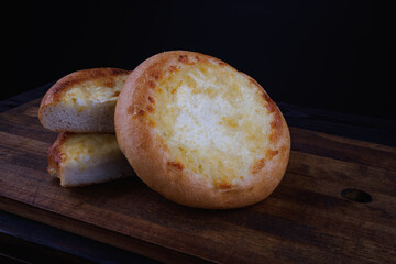 Khachapuri. Bun with cheese on a wooden background. Cheese pie.
