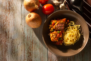 A plate of spaghetti with pork pasta in tomato sauce and pasta with pork and vegetables.