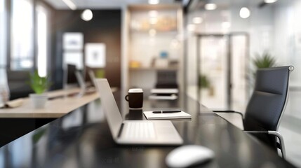 Modern office workspace with sleek black desk, laptop, and ergonomic chair. Blurred background shows glass partitions and natural light, creating a professional atmosphere.