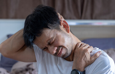 man having shoulder pain after waking up