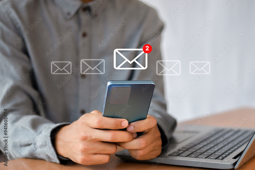 Wall mural man uses smartphone with icon notifying 2 new email messages. communication business technology.