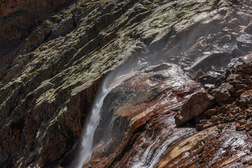 mountain cliff waterfall with strong misting wind