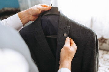 A man is holding a jacket with a button on it