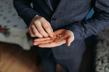 A man in a suit holding a ring in his hand