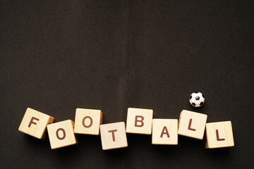 football writing from wooden cube blocks on black background