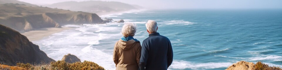 Fototapeta premium Active Senior Couple Marveling at Pacific Coast Scenery During Retirement Hike. Joyful Elderly Adventurers Embracing Nature's Beauty in Golden Years. Inspiring Lifestyle for Retirees Seeking Outdoor E