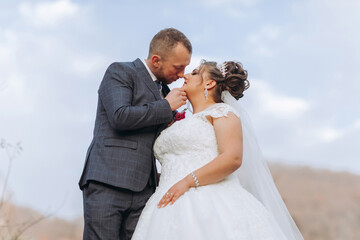 A bride and groom are kissing each other's necks