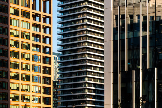 This image captures tall skyscrapers with varied architectural styles, including a brick building, a modern glass tower, and a layered residential building, highlighting urban development.