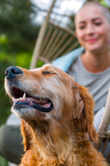 Young female cancer patient relaxing smiling in hanging chair on the patio with her emotional...