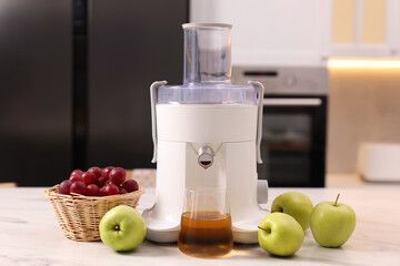 Modern juicer, fresh fruits and glass on white marble table in kitchen