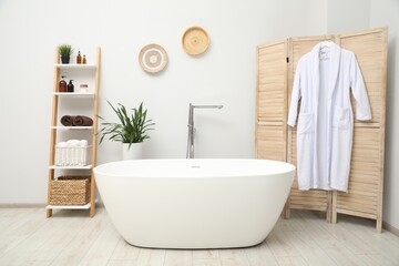 Stylish bathroom interior with folding screen and tub