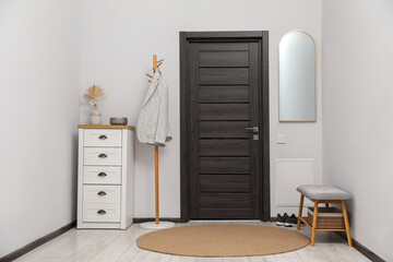 Coat rack, cabinet and shoe storage bench in hallway. Interior design