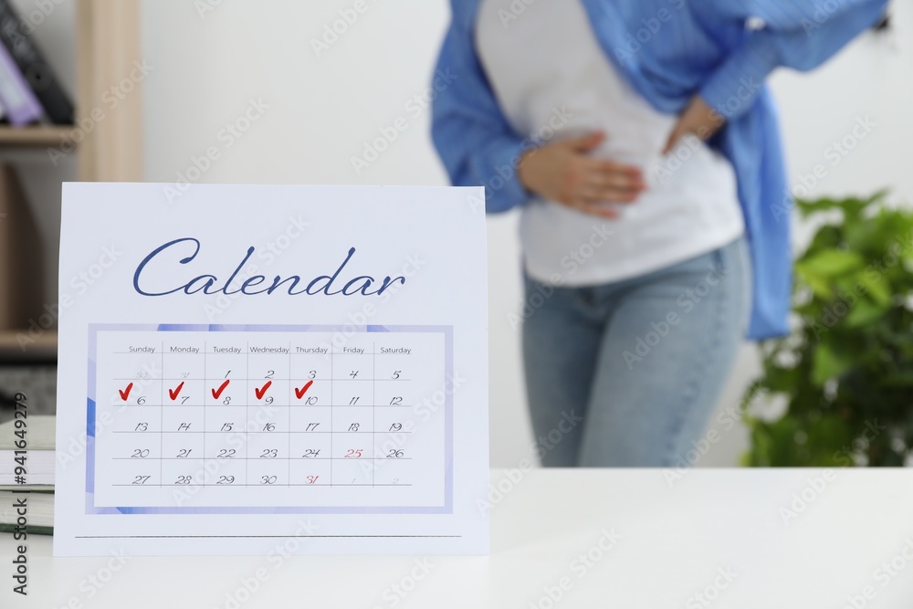 Sticker Woman suffering from abdominal pain indoors, focus on calendar with marked menstrual cycle days