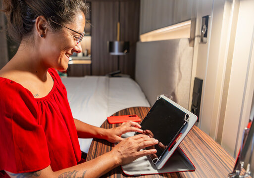 Woman in red using tablet in modern hotel room