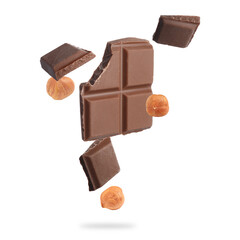 Pieces of tasty chocolate and hazelnuts falling on white background
