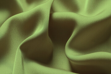Crumpled sage color silk fabric as background, closeup