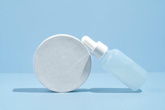 Minimalistic face care serum presentation on blue