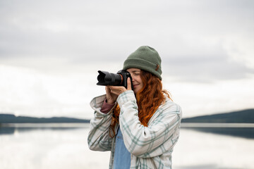 Woman taking photos at lake during camping trip