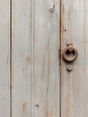 A rustic wooden door with a weathered patina, featuring an antique metal door knocker. The door is made of vertical wooden planks, adding to the texture and charm of the image. This image symbolizes h