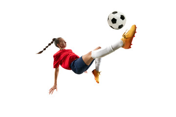 Woman in comfortable sportwear kicking soccer ball with knee in mid-air against white background....