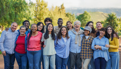 Crowd of multiracial people hugging each other and smiling in front of camera - Community and...