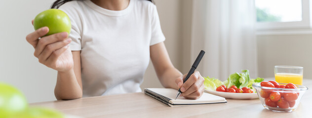 Wellbeing of health with good food control concept. Woman writing the meal note and plan to eat...