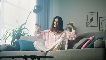 Naklejka premium Beautiful woman is sitting on a sofa and relaxing