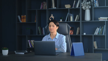 Businesswoman working on laptop in modern office