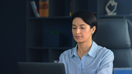 Businesswoman working on laptop in modern office