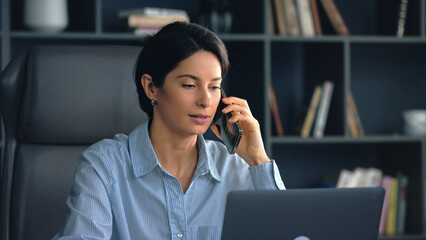 Businesswoman multitasking using laptop and