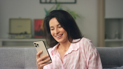 Woman laughing while reading a message on her