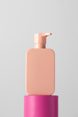 A pink mock-up of a cosmetic product with a place for a logo on the podium. 