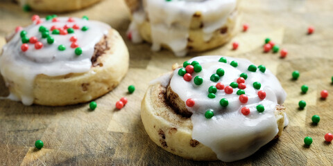 Christmas breakfast cinnamon rolls closeup for holiday gourmet sweet frosted treat with sprinkles.