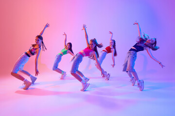 With grace and intensity, dancers bring their choreography to life on stage in neon light against...