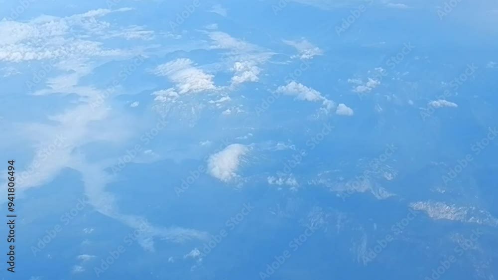 Poster aerial view from height of airplane flight of land with mountains with white stratocumulus low level