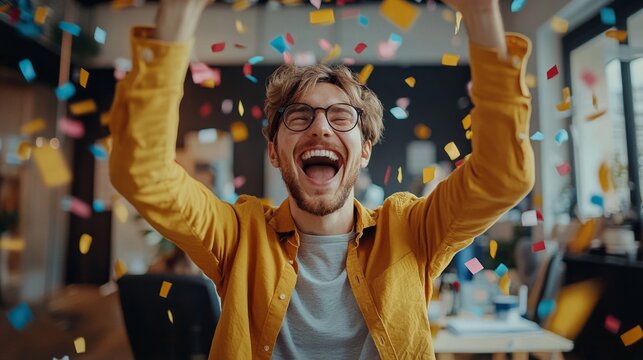 A man in a yellow shirt is throwing confetti in the air and smiling