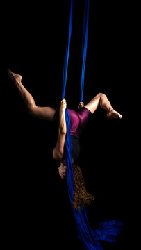 Mystical aerial dance in blue silk by acrobat woman upside down