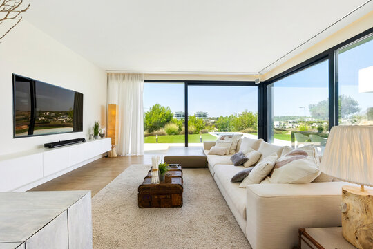 Modern living room with a view of green landscape through large windows
