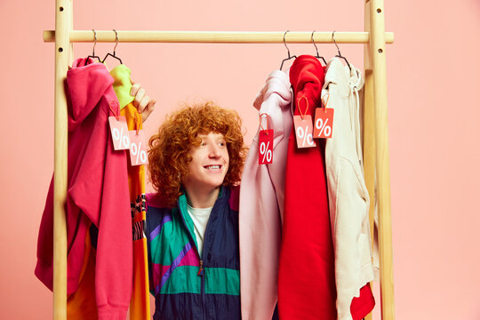 Amidst vibrant array of sale-tagged outfits, happy shopper beams with excitement, making most of markdowns on stylish finds. Concept of Black Friday, Cyber Monday, fashion, Flash Sale. Ad