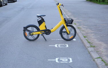 Naklejka premium A yellow rental bike is parked in the parking lot