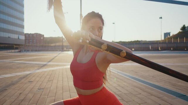 Young woman training in kung fu wushu martial arts outdoor with weapons and swords.
