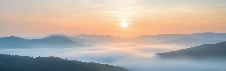 Naklejka premium Sunrise over misty mountains in early morning light