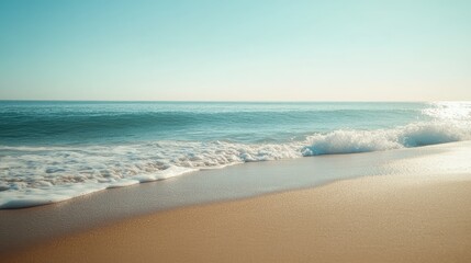 Obraz premium Wide view of gentle ocean waves rolling onto a sandy beach, with a clear sky and distant horizon --
