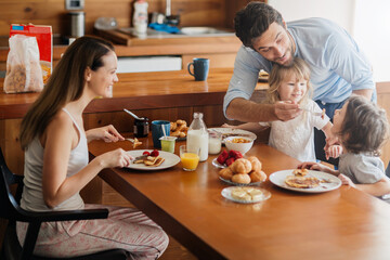 Happy family enjoying breakfast together in cozy kitchen