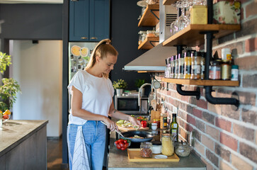 Young woman preparing fresh vegetables in a modern kitchen