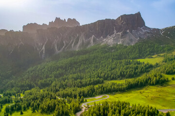 Naklejka premium Snake Road in the Dolomites. Sunrise aerial forest. Pathway from Snake Road to high mountain range in Giau Pass