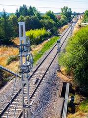 Railway tracks cutting through a rural landscape with limit info.