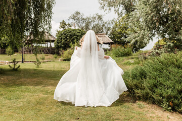 bride in white dress runs in park 