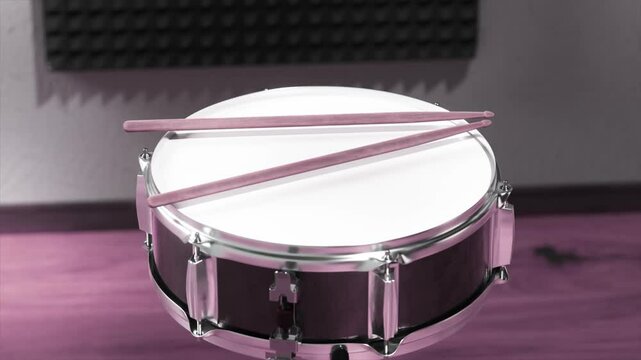 A close-up shot of a snare drum with drumsticks resting on the drumhead, set against a soundproof studio background.